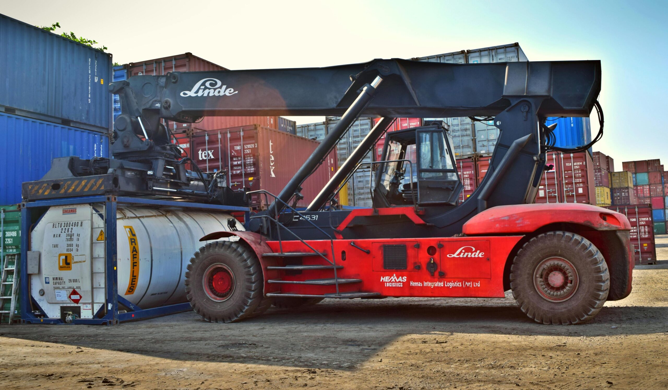Forklift operating at a cargo yard, moving large containers efficiently.